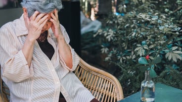 Emphasizes depressed tired sad angry Asian elderly senior Asian elderly woman sitting in garden.