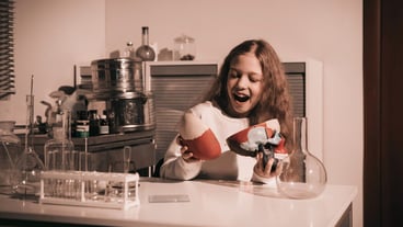 Happy schoolgirl girl sitting at a table in her lab. the concept of education and hobby