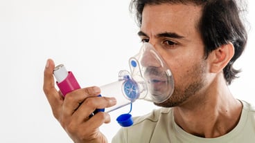 Asian young man from india using a respiratory inhaler Study shot on white background selective focus