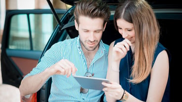 Beautiful young lovers using a tablet