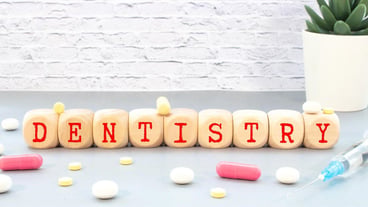 Medicine concept An arrow of pills points to a sign that says DENTISTRY