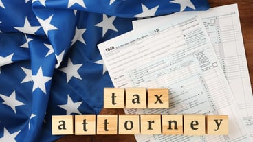 Wooden cubes with space for text and income tax form with American flag on table Tax attorney concept