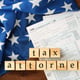Wooden cubes with space for text and income tax form with American flag on table Tax attorney concept