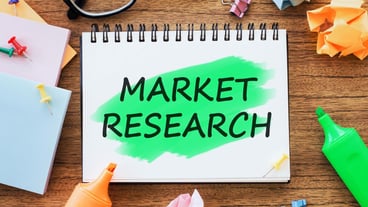 Office wooden table with a notebook MARKET RESEARCH with markers paper clips crumpled paper Business concept top view