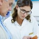 Pharmacist woman and man with box pills and helping hand for choice with benefits info or side effects People medicine or drugs with advice consulting and healthcare with supplements at store