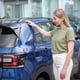 Beautiful mature woman shopping for new car at auto dealership
