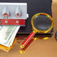 Finding and buying a home over the Internet House model on the background of a laptop and a magnifying glass