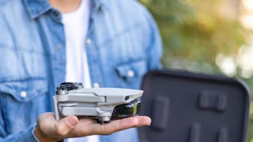 Selective focus close up view of a folded helicopter remotecontrolled toy resting on the hands of an unrecognizable boy