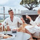 Beautiful mature couple in bathrobes enjoying fruits and wine while relaxing in luxury hotel outdoors