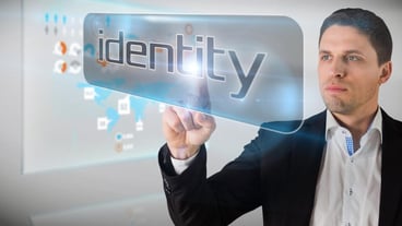 Businessman pointing to word identity against technology interface