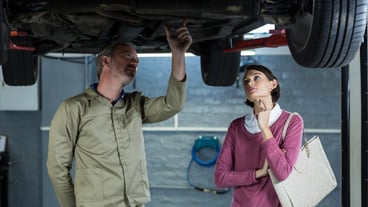 Mechanic showing customer the problem with car