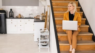 Remote work at home, freelance during covid-19 quarantine. Smiling lady sitting and working on laptop in cozy living room interior, free space.