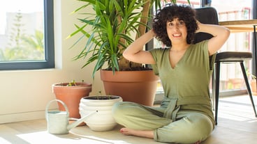 Young pretty woman with a watering can and plants