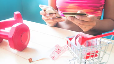 Fitness healthy young woman using mobile phone and holding credit card, Online shopping