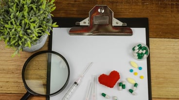 High angle view of the clipboard with medical equipment on the table