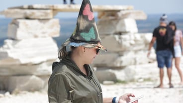 People with witches' hats on a trip to a secret logoa among the rocks and waterfalls in the mountain
