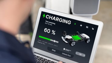 Qualified technician working on home EV charging station installation making troubleshooting and configuration setup on charging system with laptop for EV at home Synchronos