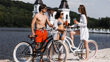 Three friends with bicycles on the beach