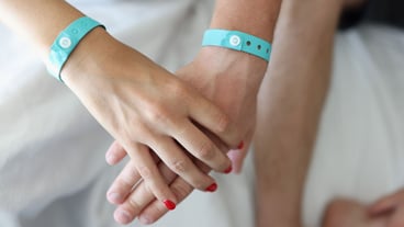 Male female hands holding hands with bracelets