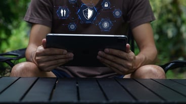 Person Using Tablet in Nature with Security and Network Icons