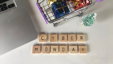 Cyber monday text with shopping cart on table