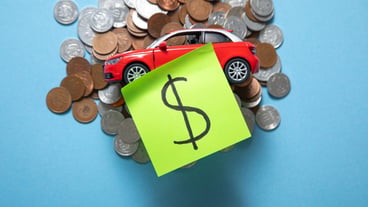 Red toy car and coins on a blue background.