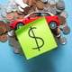 Red toy car and coins on a blue background.