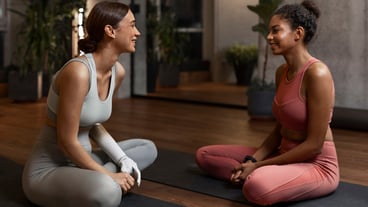Side view smiley women on yoga mats