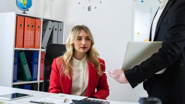 Two financial analysts working together with paper charts and laptops at office