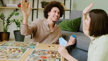 Couple doing high five while playing board game