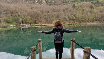 Rear view of woman walking on pier over lake
