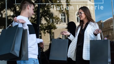 Portrait of young woman and man with shopping bags. Successful shopping concept. Young couple after shopping. Black Friday.