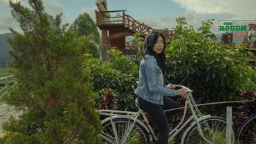 Asian female riding bicycle with mountain background view