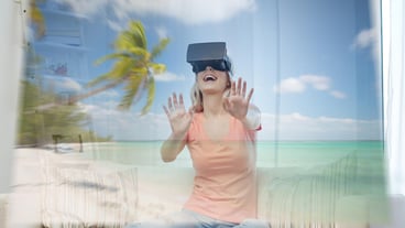 technology, augmented reality, cyberspace, entertainment and people concept - happy young woman wearing virtual headset or 3d glasses with exotic tropical beach projection at home