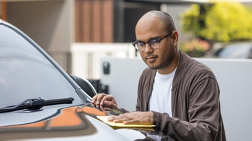 Young asian man uses a microfiber cloth and polish to wipe the car's  to make them shine He takes care of every detail of the car.