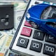 Blue toy car with real keys calculator over us dollar banknotes