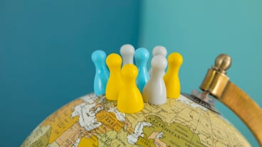 Pawns on world globe with blue background