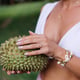Young stylish woman holding durian fruit