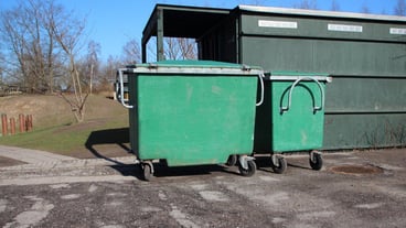 Garbage bins on road against sky