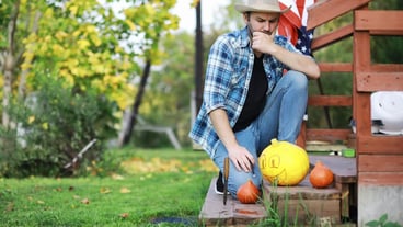 Autumn traditions and preparations for the Halloween party. A house in nature. A lamp is carved from pumpkins on the table.
