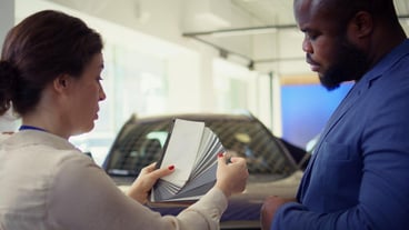 Car showroom agent providing customer with color wheel tinting selection