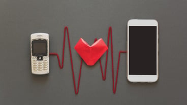 Old phone and new smartphone are connected by a red pulse on a gray paper background