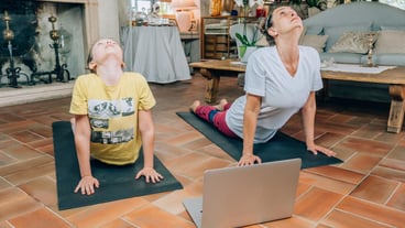 Full length of mother and daughter sitting on floor at home