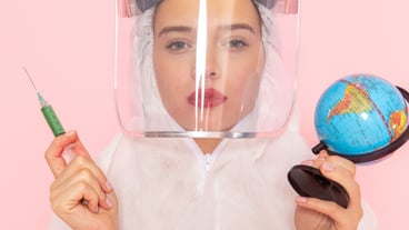 young beautiful female in special white suit wearing protective helmet holding injection globe on pink