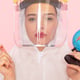 young beautiful female in special white suit wearing protective helmet holding injection globe on pink
