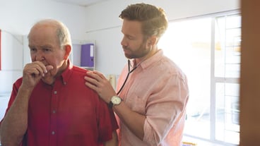 Male doctor examining a senior patient thanks to a stethoscope
