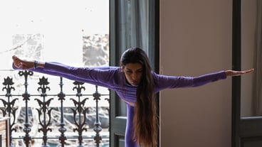 Woman stretching legs while practicing yoga at home