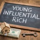 Young influential rich concept with cash house model and key for wealth real estate and financial