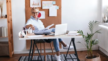 Charming lady in a blue outfit, sitting in the office and enjoying coffee
