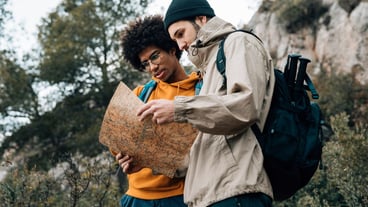Low angle view of hiker reading the map while hiking in nature
